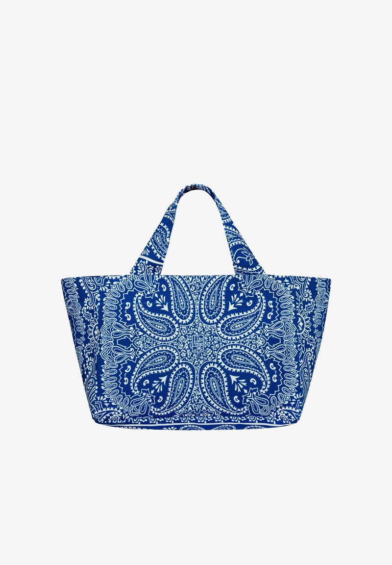 Torba na ramię z niebiesko-białej tkaniny z wzorami paisley i kwiatowymi, dwoma krótkimi uchwytami, szerokim trapezowatym kształtem i skomplikowanym, symetrycznym wzorem.