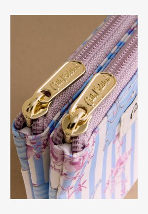 Kukkakuvioinen kangaslompakko, jossa sinivalkoiset raidat. Siinä on kaksi kultaa olevaa metallivetoketjua, joissa on teksturoidut vetimet ja kangassomisteet.