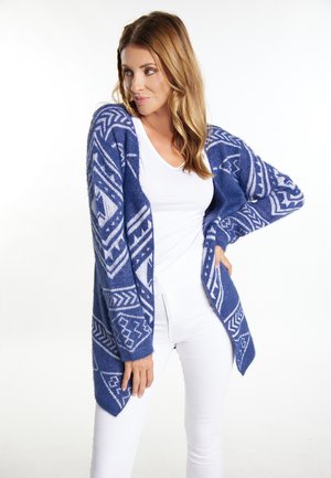 Long blue cardigan featuring white geometric patterns, made of textured knit material with an open front and pointed hem.