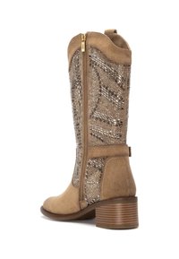 Bota de gamuza color marrón claro hasta la rodilla con un incrustado metálico texturizado, cremallera lateral y un tacón apilado similar a la madera. Costuras acentuadas en la parte superior.