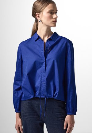 Blauw overhemd met knopen en een cropped ontwerp, elastische manchetten en een drawstring zoom. Gemaakt van een gladde stof met een lichte glans.