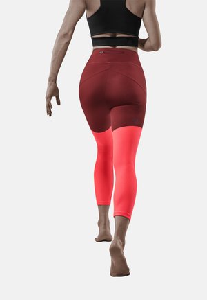Hoch geschnittene, figurbetonte Leggings in Burgunderrot und leuchtendem Koralle mit atmungsaktiven Mesh-Bereichen, die einen glatten Stoff und ein ergonomisches Design bieten.