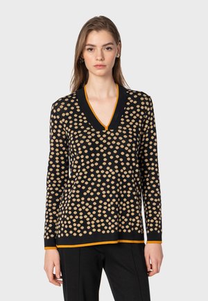 Black sweater with tan polka dots, V-neck design, long sleeves, and orange accent at neckline and hem. Soft texture.