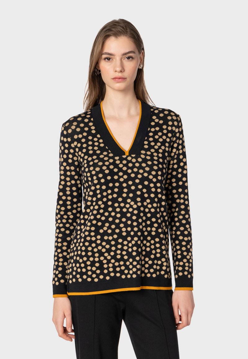 Maglione nero con pois beige, design a V, maniche lunghe e accento arancione sul collo e sull'orlo. Texture morbida.