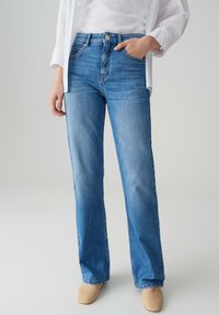 Lichtblauwe high-waisted jeans van denim met een relaxte pasvorm, voorzien van voorzakken, contrasterende stiksels en een knoopsluiting.