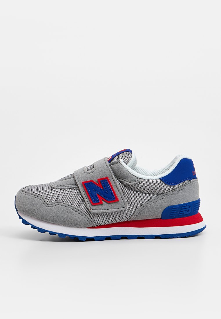 Bottines de sport grises en matériaux mesh et daim. Présentent une sangle bleue et rouge, des accents de logo et une semelle blanche avec des détails bleus.