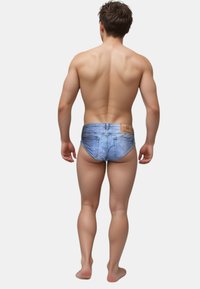 Denim-Schwimmbrieftaschen mit einer hellblauen Waschung, falschen Taschen und einem braunen Label auf der Rückseite. Designed für einen engen Sitz. Nahtlose Konstruktion.