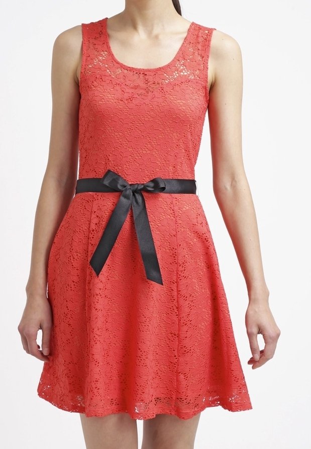 Robe en dentelle rouge avec un col bateau, jupe fluide et une ceinture en satin noir nouée à la taille. Présente un motif floral texturé.