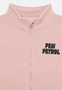 Chaqueta de forro polar rosa con un alto cuello, cremallera frontal y logotipo bordado en negro de "PAW PATROL". Textura suave, diseño sin costuras.