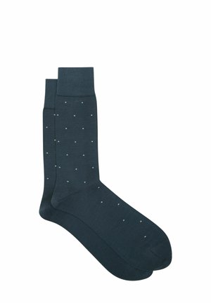 Tummansiniset puuvillasukat, joissa on sileä pinta, pienillä, tasaisesti välimatkoilla olevilla valkoisilla pisteillä ja ribbiresorilla.