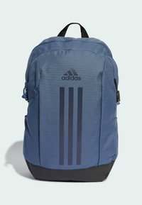 Blue fabric backpack with a black bottom, featuring three vertical black stripes and the Adidas logo on the front. Zippered compartments visible.