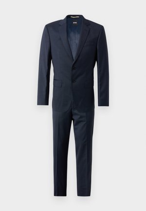 Donker marineblauwe twee-delige kostuum van gladde stof, met een blazer met twee knopen en revers en rechte broek.