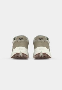 Buty Hi-Tec z beżową i szaro-zamszową cholewą, białą podeszwą środkową i brązową gumową podeszwą. Charakteryzują się rozpoznawalnym logo Vibram na pięcie.