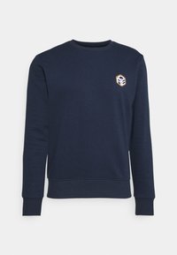 Námořnická mikina s dlouhými rukávy, žebrovanými manžetami a kulatým výstřihem. Má malé geometrické logo na levém prsu. Vyrobena z jemné tkaniny.