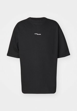 Μαύρο φαρδύ κοντομάνικο T-shirt με λευκή γραφή "LOVE SCARS" κεντραρισμένη στο στήθος σε απλό ανοιχτό φόντο.