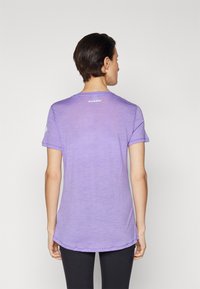 T-shirt corto viola, realizzato in tessuto leggero. Presenta un collo rotondo e un orlo curvo. Marchio visibile sul retro.