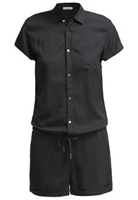 Combinaison courte noire à manches courtes en tissu doux, avec fermeture boutonnée à l'avant, poche poitrine, taille ajustable par cordon, et revers aux ourlets du short.