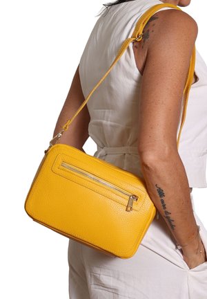 Borsa a tracolla gialla in pelle con finitura testurizzata, forma rettangolare, tracolla regolabile e tasca frontale con cerniera.