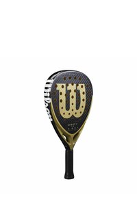 Wilson padelracket met een zwarte composieten kop met gouden accenten, hexagonale patronen en een gestructureerde grip handvat.