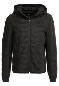 Svart vadderad jacka med huva, med en full dragkedja fram, sidofickor och strukturerade zigzag-mönster på ett slätt material.