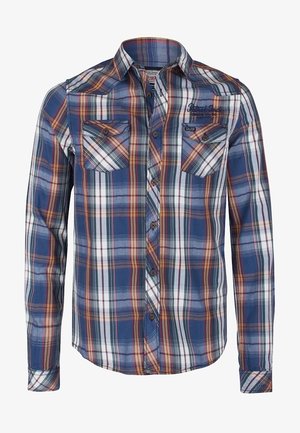 Camisa de manga larga abotonada con patrón a cuadros en azul, blanco, rojo y amarillo, y dos bolsillos frontales en el pecho con botones.