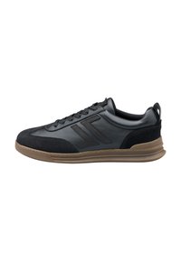 Black leather sneaker with suede toe and heel, brown rubber sole, lace-up front, and angular stitched logo on the side.