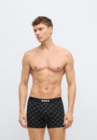 Crne bokserice s dijamantnim uzorkom, elastični pojas s logotipom "BOSS", uski kroj i glatka tekstura.