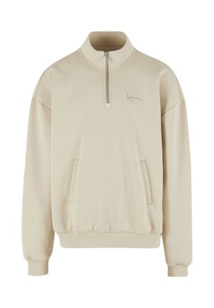 Beež värvi pika varrukaga pullover, millel on pool-zipp krae, esimesed taskud ja soonilised varrukaotsad. Pehme kangas, millel on rindkere peal õrn logo detail.