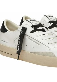 Baskets en cuir blanc avec des accents noirs, des détails en daim texturé, des lacets plats et une étiquette de logo. Dotées d'un bout arrondi et d'une semelle en caoutchouc texturé.