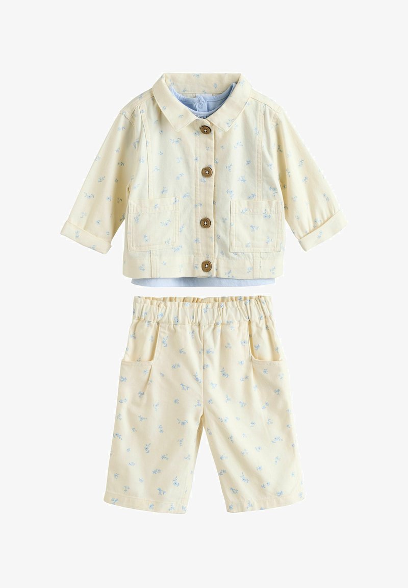 Light yellow two-piece outfit featuring a collared jacket with wooden buttons and matching shorts, both adorned with a small blue floral pattern.