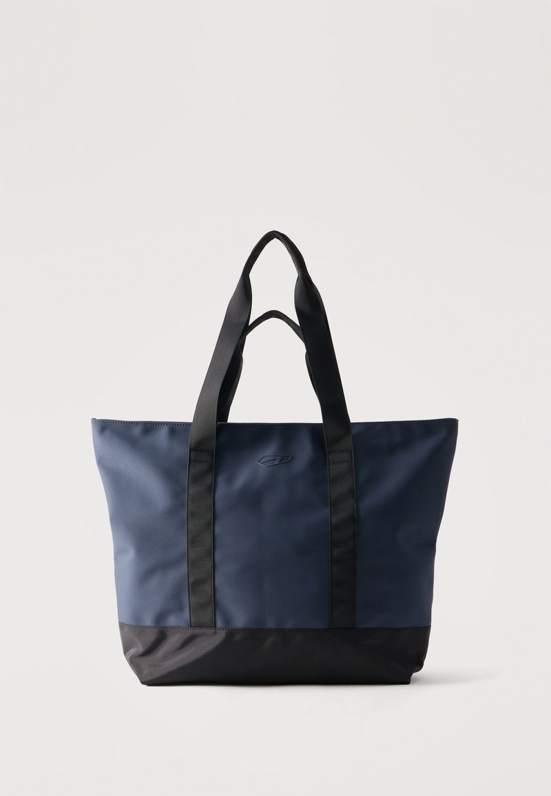 Τσάντα tote σε ναυτικό μπλε και μαύρο χρώμα με διπλές μαύρες λαβές, μεσαίου μεγέθους, ορθογώνιο σχήμα, όρθια σε απλό φόντο.