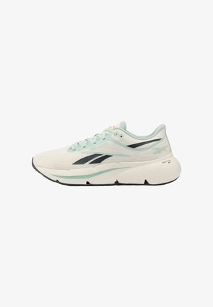 Chaussure de course beige clair et vert menthe avec logo noir, semelle épaisse amortie et dessus en mesh respirant, vue latérale.