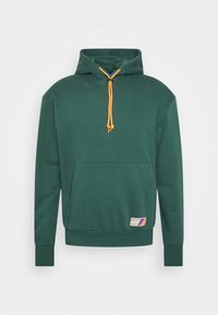 Felpa verde con cappuccio realizzata in tessuto morbido, con una tasca a marsupio, coulisse arancione e una piccola toppa con logo sull'orlo.