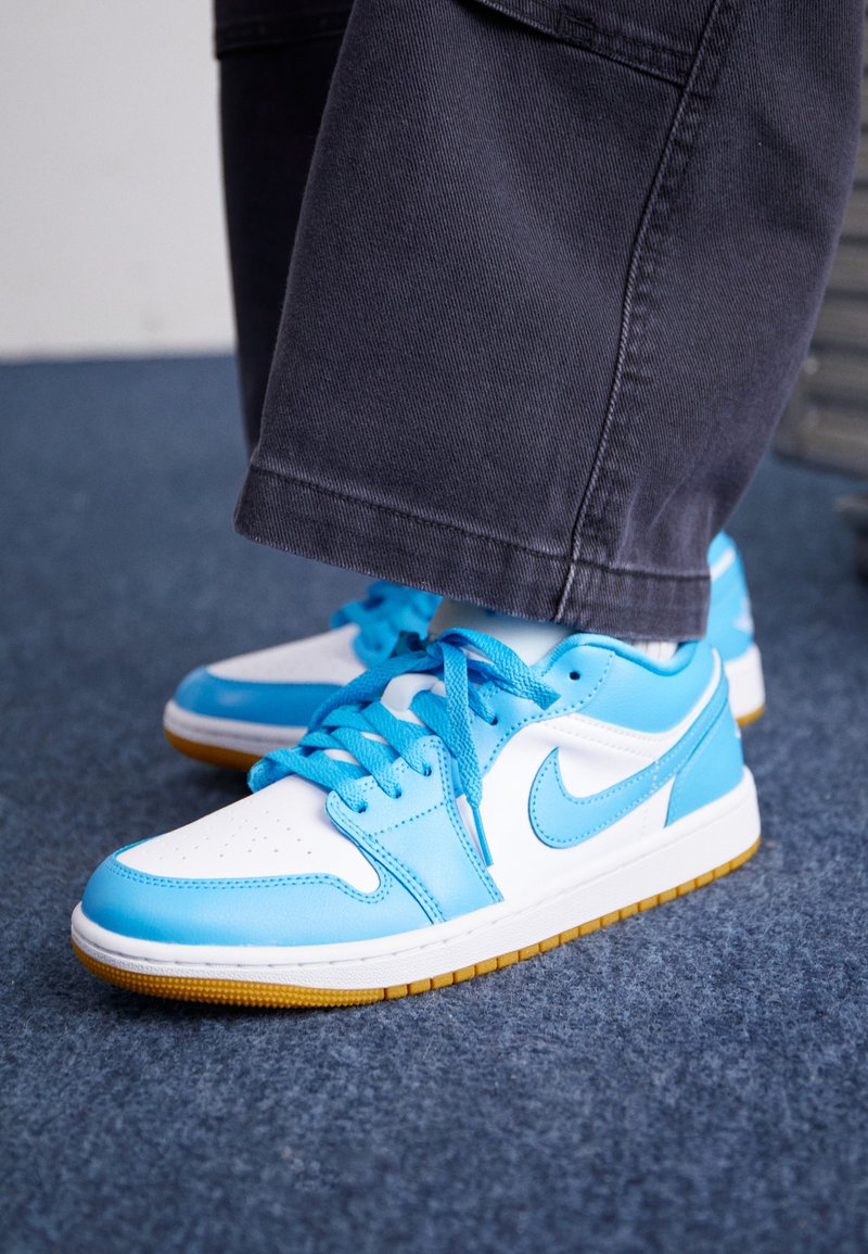 Sneaker in pelle blu e bianca con suola in gomma, caratterizzate da pannelli testurizzati e lacci coordinati. Logo sul lato, cuciture a contrasto discrete.
