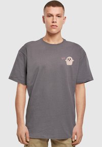 Grå kortærmet t-shirt lavet af bomuld. Har et lille pink spøgelse med teksten "Boo!" på brystet. Regulær pasform, rund halsudskæring.