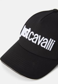 Schwarze Baseballmütze aus Stoff mit weiß gesticktem Text "Justcavalli" auf der Vorderseite, mit kontrastierender Akzentstreifen am Schirm.