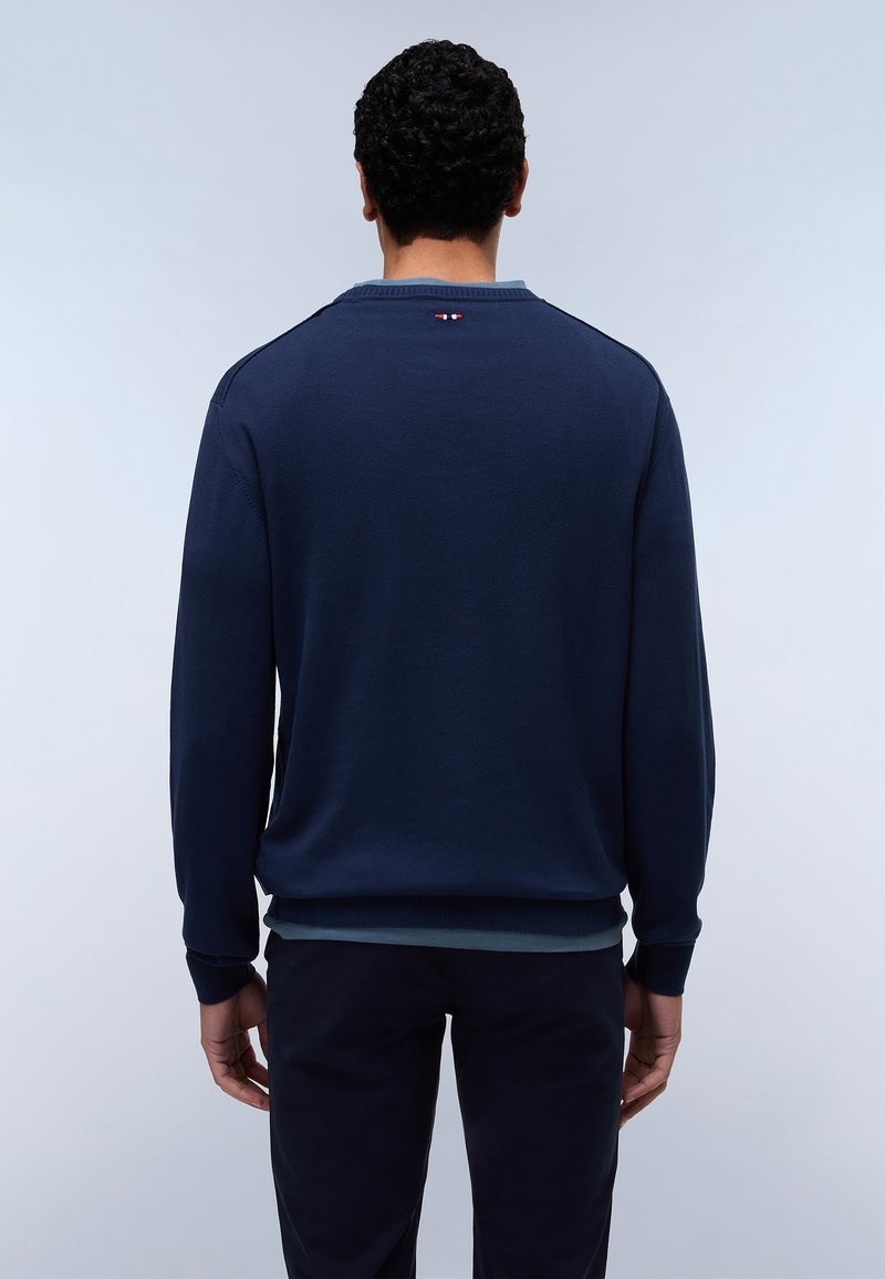 Granatowy sweter z długimi rękawami, prążkowanymi mankietami i dolną krawędzią, minimalistyczny design z małym akcentem kolorystycznym przy dekolcie.