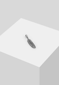 Silverfjäderhänge med detaljerade ådringsmönster; slät yta; ögla för fäste. Mot en vit geometrisk bakgrund.