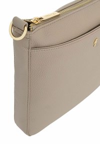 Beżowa skórzana torebka kopertówka o teksturowanym wykończeniu, z zamknięciem na zamek i złotym uchwytem zamka. Posiada zewnętrzną kieszeń oraz okrągły detal hardware.