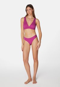 Lila texturerad bikinitopp och midjereså med V-ringning, båda med minimalistisk design och sömlösa kanter.