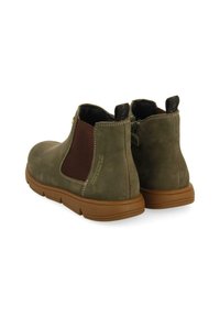 Stivaletti Chelsea in pelle verde oliva con pannelli elastici laterali marroni, cuciture a contrasto e suole in gomma per flessibilità e comfort.