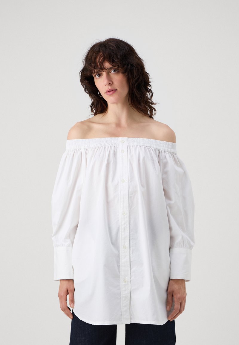 Camicia bianca off-the-shoulder realizzata in cotone, con maniche a sbuffo, chiusura frontale con bottoni e parte superiore elasticizzata per un fit rilassato.