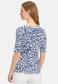 Navy og hvid leopardprint top med korte ærmer, rund halsudskæring og en afslappet pasform, lavet af blødt, tekstureret stof.