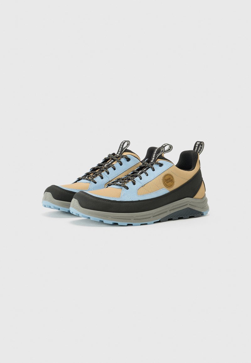 Zapatos de senderismo con una mezcla de tela azul, acentos en beige, puntera de goma negra y suela gris. Presentan una superficie texturizada y cordones en contraste.
