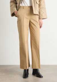 Beige wijde broek van katoen, met een zachte textuur, twee voorkruiden en een persplooi langs de benen.