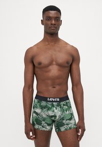 Moški Levi's bokserice v vzorcu zelenega lista. Tkanina je raztegljiva, s črnim pasom, na katerem je logo Levi's.
