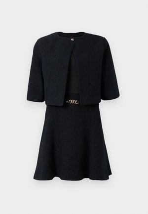 Black twill dress with short sleeves, featuring a cropped jacket and flared skirt, accented by a gold-toned belt detail at the waist.