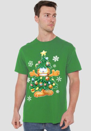 Grünes Baumwoll-T-Shirt mit einem grafischen Druck eines Cartoon-Charakters, der als Christbaum dargestellt wird, versehen mit Ornamenten und Schneeflocken.