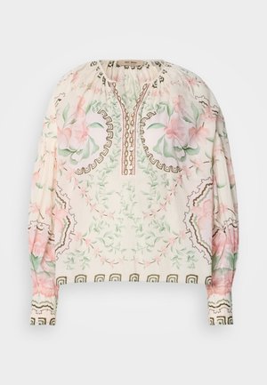 Letvægtsbluse i cremefarvet med blomstermotiv i pink og grøn. Har en samlet halsudskæring og indviklede brune detaljer. Lange ærmer.