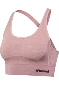 Bezszwowy różowy biustonosz sportowy z krzyżowanymi ramiączkami z tyłu i fakturowaną tkaniną, z czarnym logo hummel na dolnej taśmie.